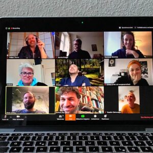 Das Foto eines Laptop-Bildschirms zeigt neun Teilnehmende der Videokonferenz, die diesem Podcast zugrundeliegt