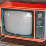 Ein alter Röhrenfernseher mit knallrotem Gehäuse.
