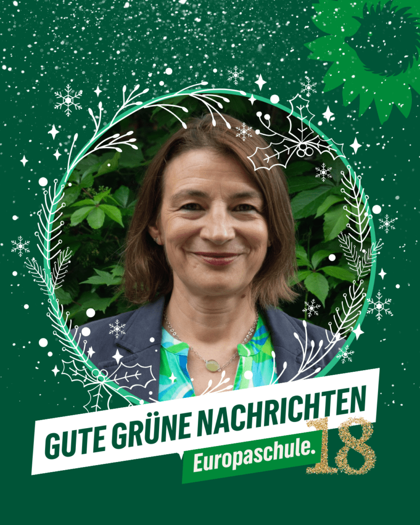 Porträt einer Frau vor grünem, winterlich illustriertem Hintergrund mit Kranz aus Zweigen, Schneeflocken und Sternen. Unten der Schriftzug „GUTE GRÜNE NACHRICHTEN – Europaschule“. Rechts die goldene Zahl 18 als Nummer des Türchens. Oben rechts das Logo: Sonnenblume mit Igel-Silhouette von B’90/GRÜNE in Berlin.