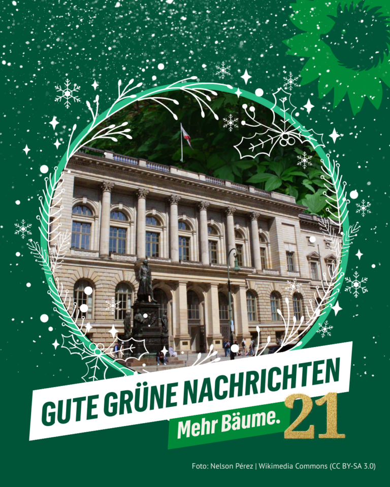 Historisches Gebäude des Berliner Abgeordnetenhauses, umrahmt von einem grünen, weihnachtlichen Kranz. Darüber der Schriftzug „Gute grüne Nachrichten – Mehr Bäume“. Rechts unten die goldene Zahl 21. Oben rechts das Logo von B’90/GRÜNE in Berlin: Sonnenblume mit Igel-Silhouette. Foto: Nelson Pérez | Wikimedia Commons (CC BY-SA 3.0).