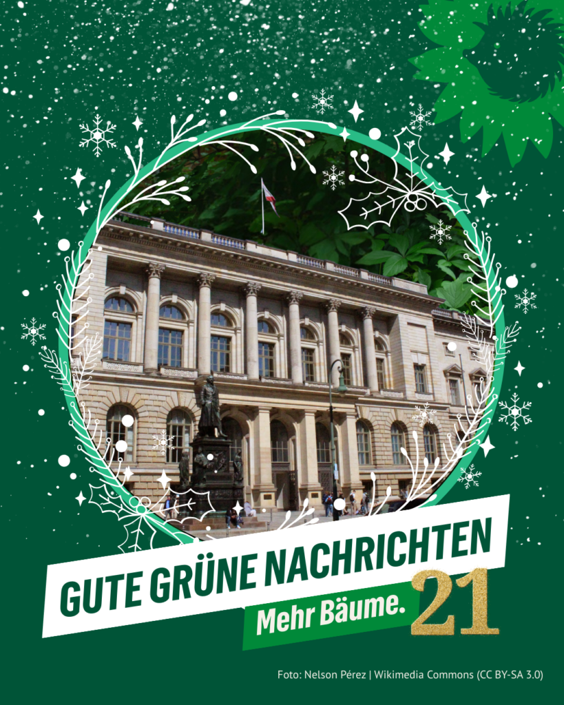 Historisches Gebäude des Berliner Abgeordnetenhauses, umrahmt von einem grünen, weihnachtlichen Kranz. Darüber der Schriftzug „Gute grüne Nachrichten – Mehr Bäume“. Rechts unten die goldene Zahl 21. Oben rechts das Logo von B’90/GRÜNE in Berlin: Sonnenblume mit Igel-Silhouette. Foto: Nelson Pérez | Wikimedia Commons (CC BY-SA 3.0).